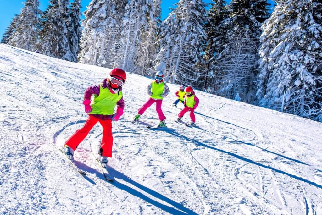 enfant avec dossard école de ski pendant un cours