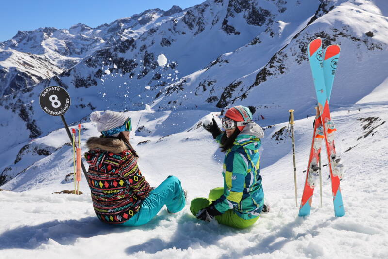 Les stations de ski Station de ski de superbagneres sous une couche de neige fraiche et le soleil levant sur la vallée de luchon dans les pyrénées Amies prenant la pose au sommet des pistes de superbagneres, profitant de la vue panoramique